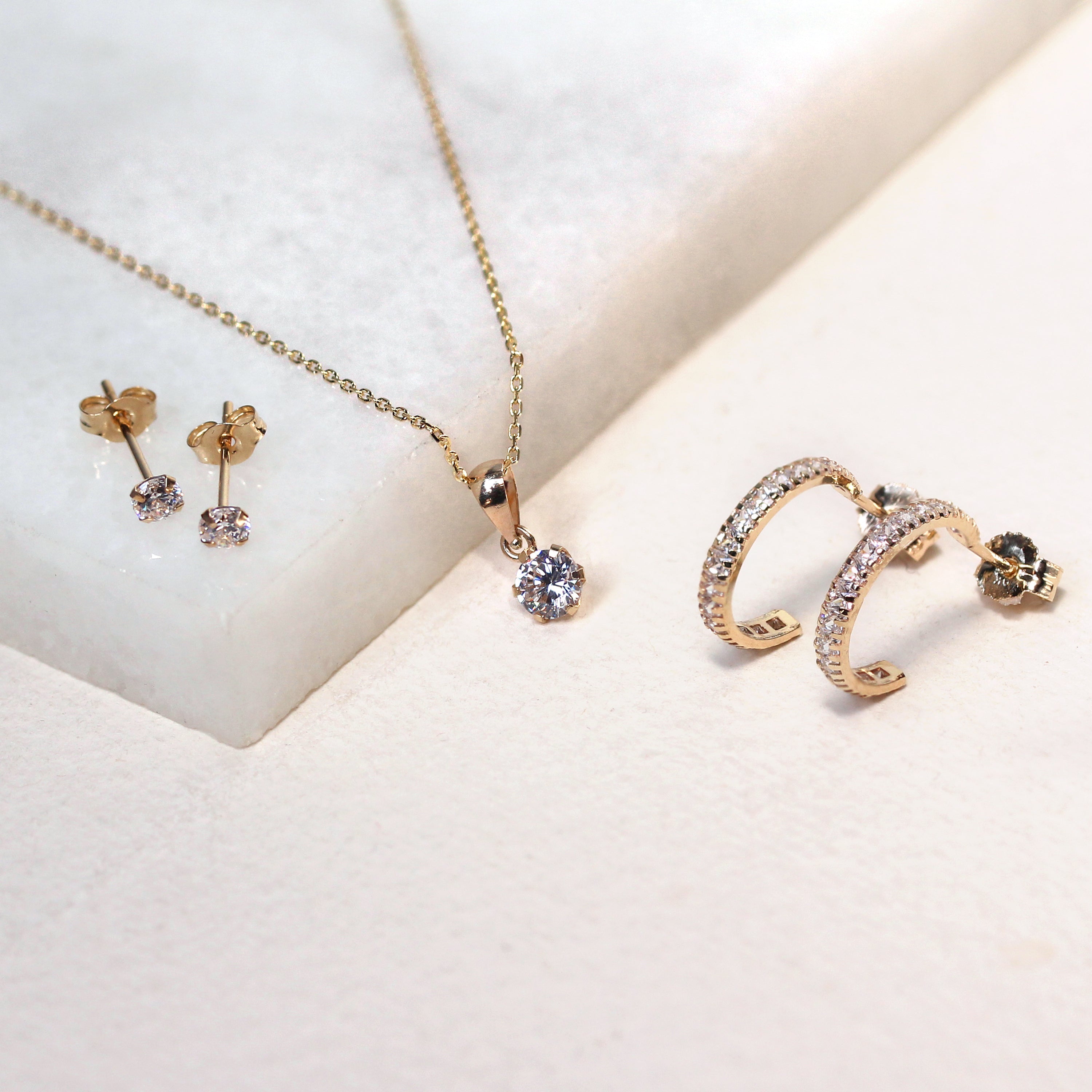 Huggie-Creolen aus 9 Karat Gold mit Zirkonia-Geburtsstein und Pavé-Besatz