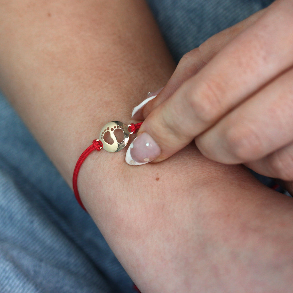 Verstellbares Armband aus 9 Karat Gold mit Babyfüßen und farbiger Kordel